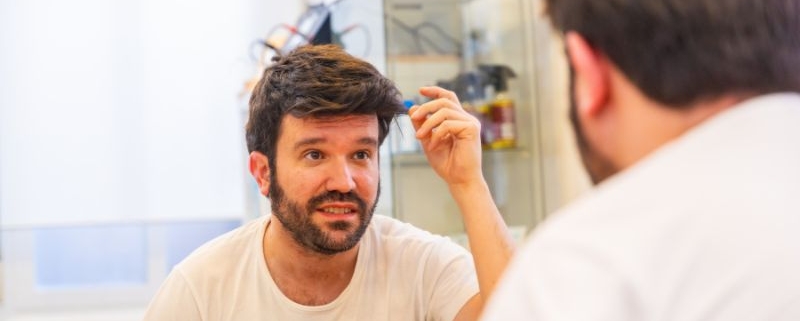 hombre con prótesis capilar de hombre en un salón de barbería